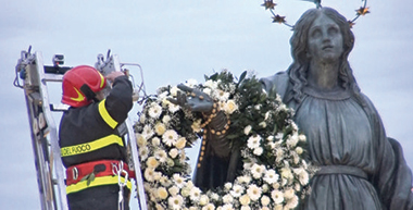 I vigili del fuoco mentre porgono la corona di fiori.