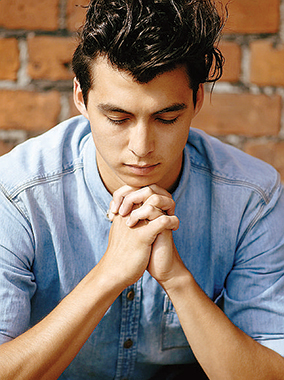 Giovane in pregghiera. Peopleimages / Istock